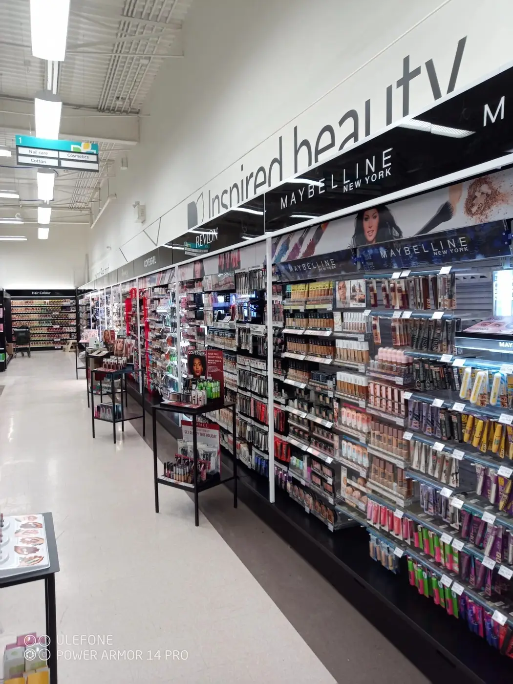 Rexall beauty aisle with lit shelving and a polished floor